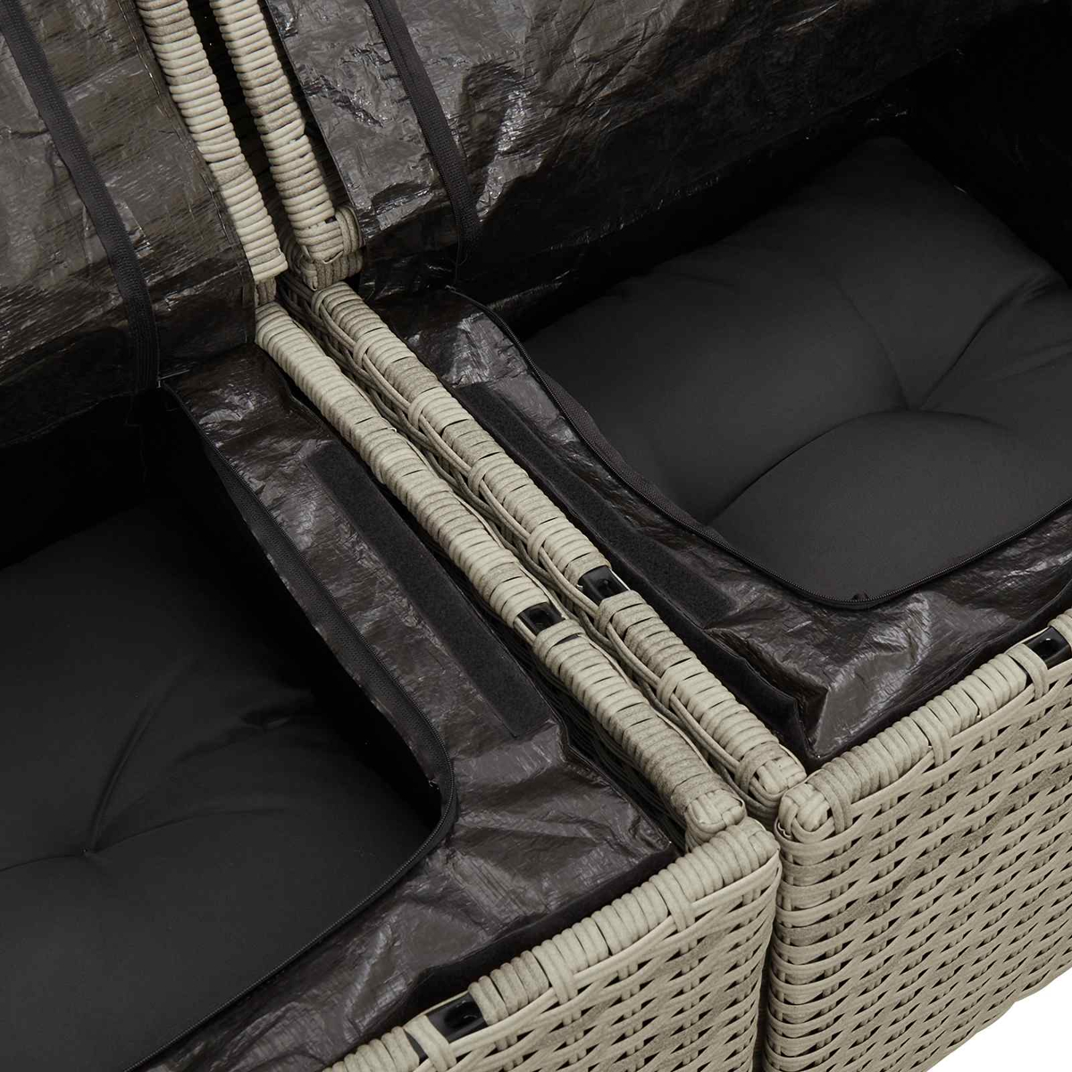 Graue Rattansofakissen unter schwarzer Schutzhülle.