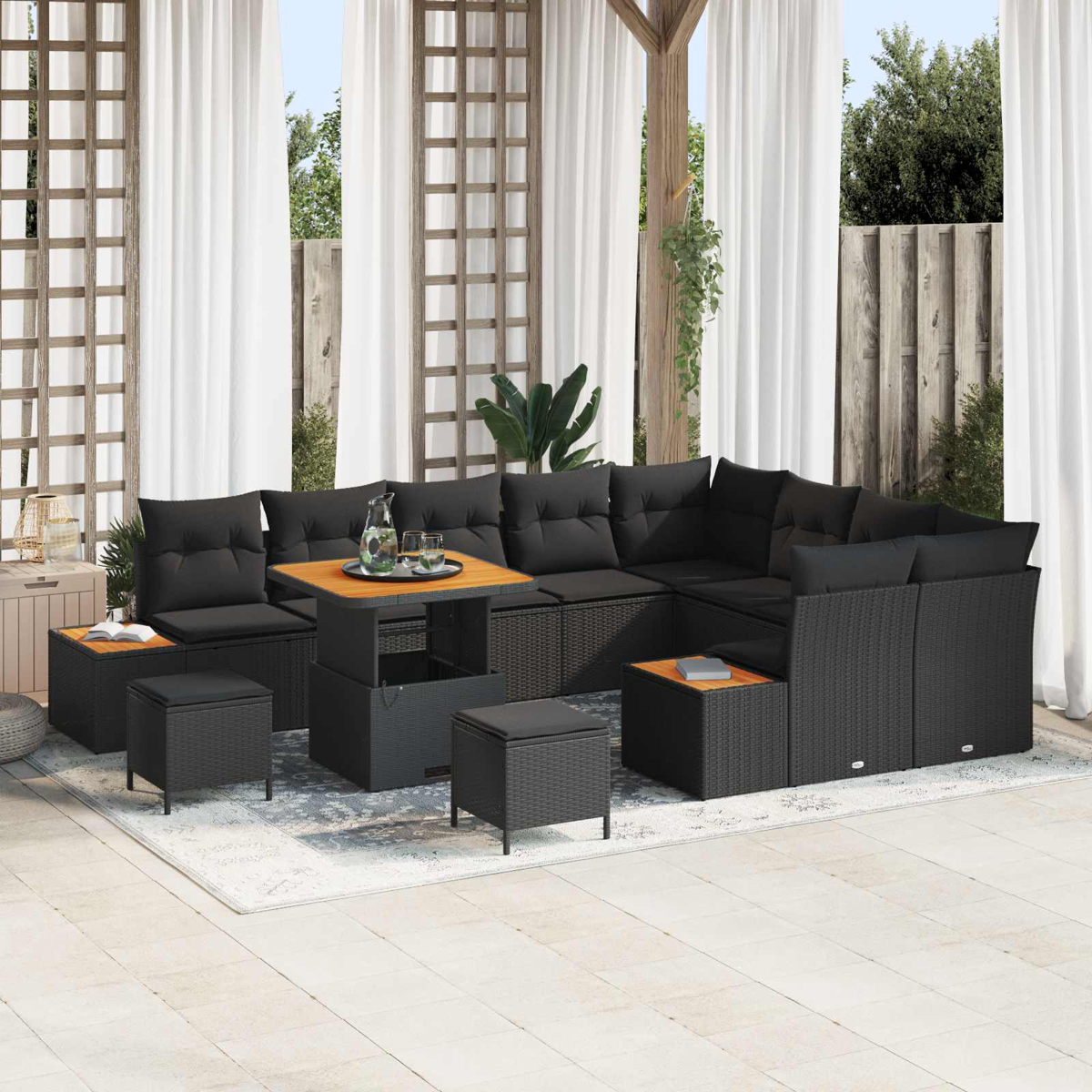 Un divano nero in rattan con cuscini e un tavolo su un patio.