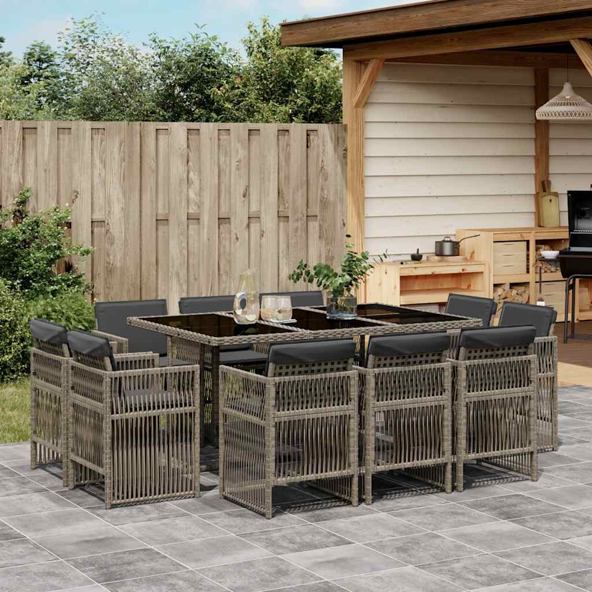 Ein großer Esstisch aus Rattan mit acht Stühlen unter einem Holzpavillon.