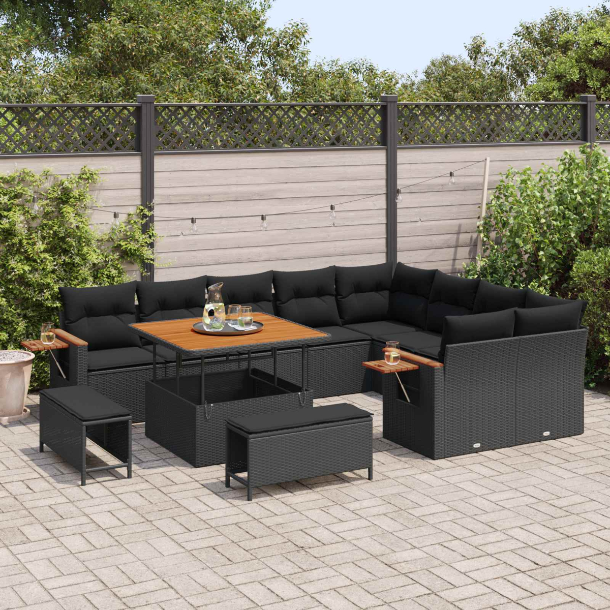 Muebles de exterior grises oscuros con cojines negros y mesa de madera en patio.