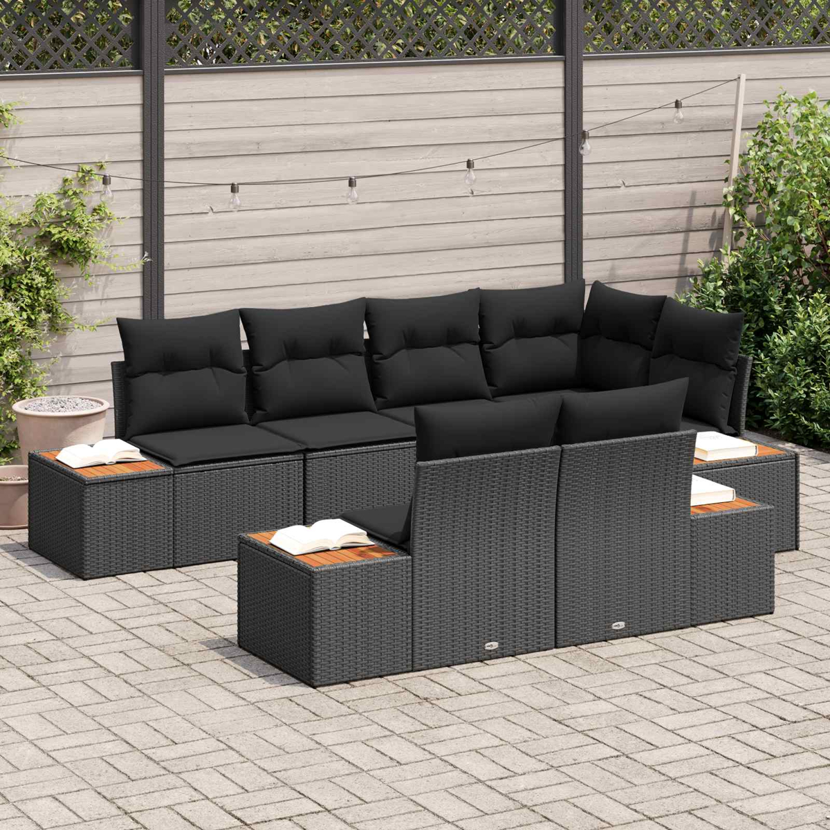 Außen-Sectioal-Sofa mit schwarzen Kissen und Tischen mit Holzoberfläche auf einer Terrasse.