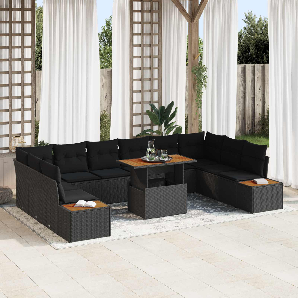 Schwarzes Geflecht-Sofa mit Holzmittelplatte auf einer Terrasse mit weißen Vorhängen.