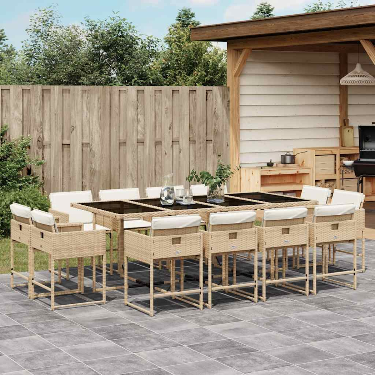 Ein Esstisch aus Rattan mit weißen Kissen und Stühlen auf einer Terrasse.