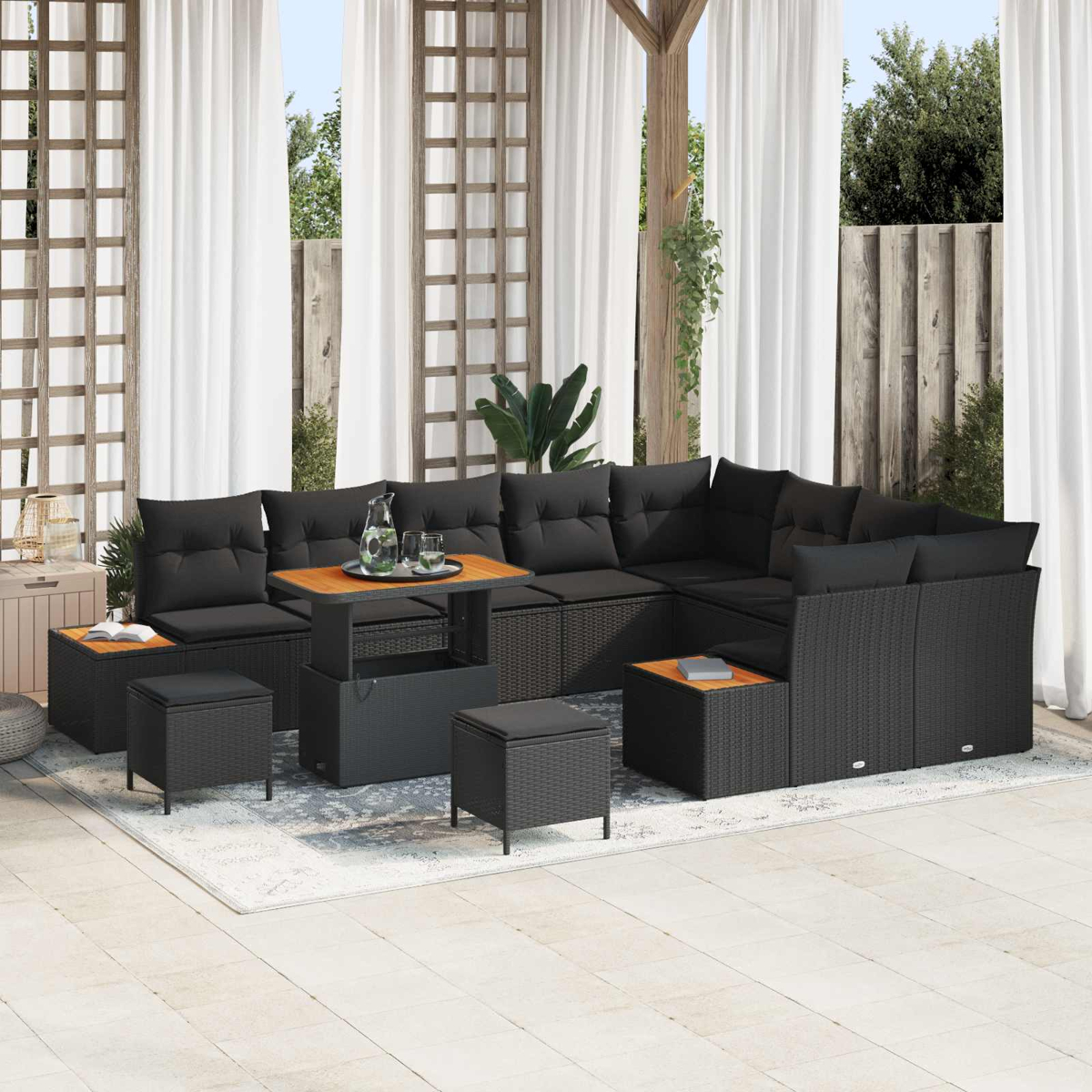 Dunkelgraue Lounge-Garnitur mit Tisch und Hockern auf einer Terrasse.