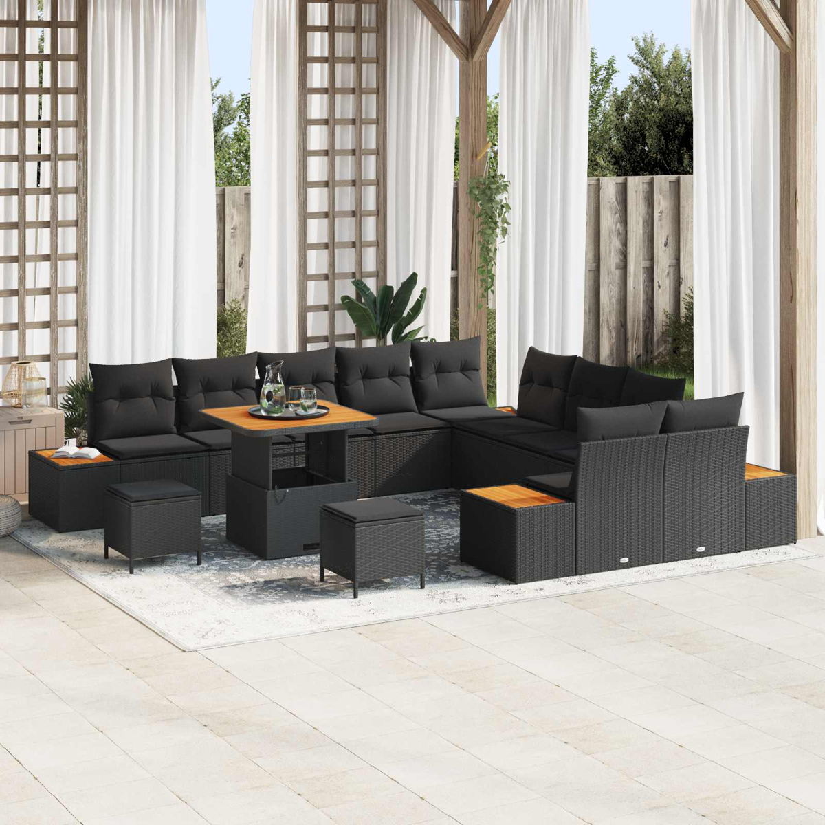 Ein schwarzes Rattan-Lounge-Set mit Kissen und einem Tisch auf einer Veranda.