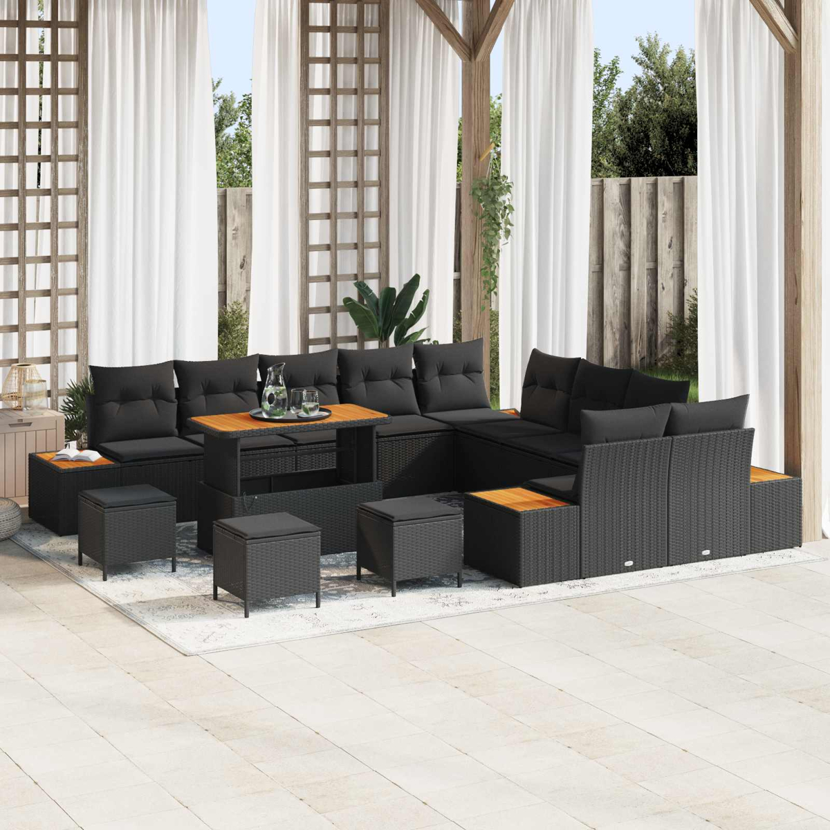 Un divano componibile in rattan grigio con cuscini neri e tavolo in legno su un patio.
