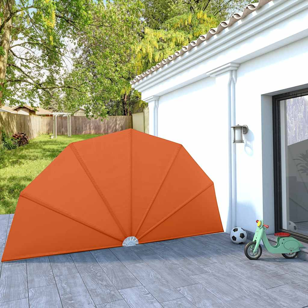 Ein orangefarbener Sonnenschutz steht auf einer Terrasse neben einem Haus. Ein grüner Roller steht daneben.