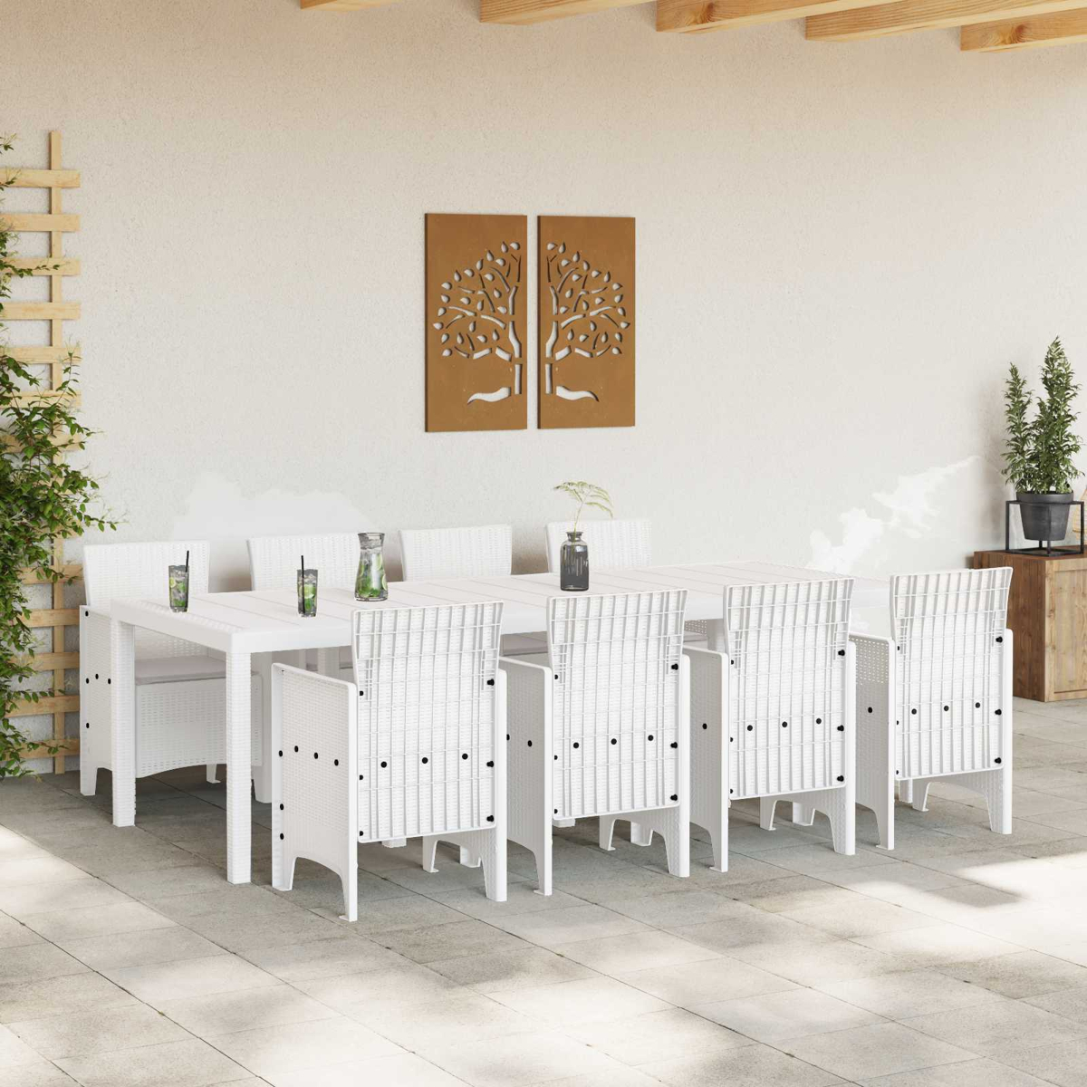 Weiße Rattansitzgarnitur mit Tisch und Stühlen im Freien unter einer Pergola.