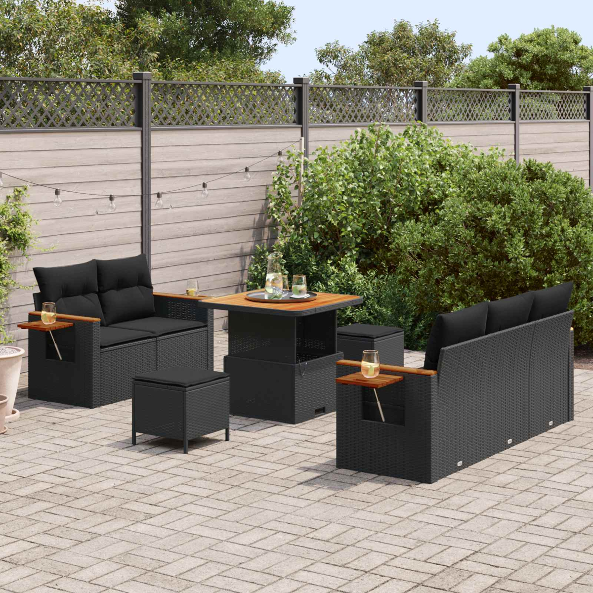 Ein moderner Gartenmöbel-Set mit einem Tisch und zwei Sofas auf einer gepflasterten Terrasse.