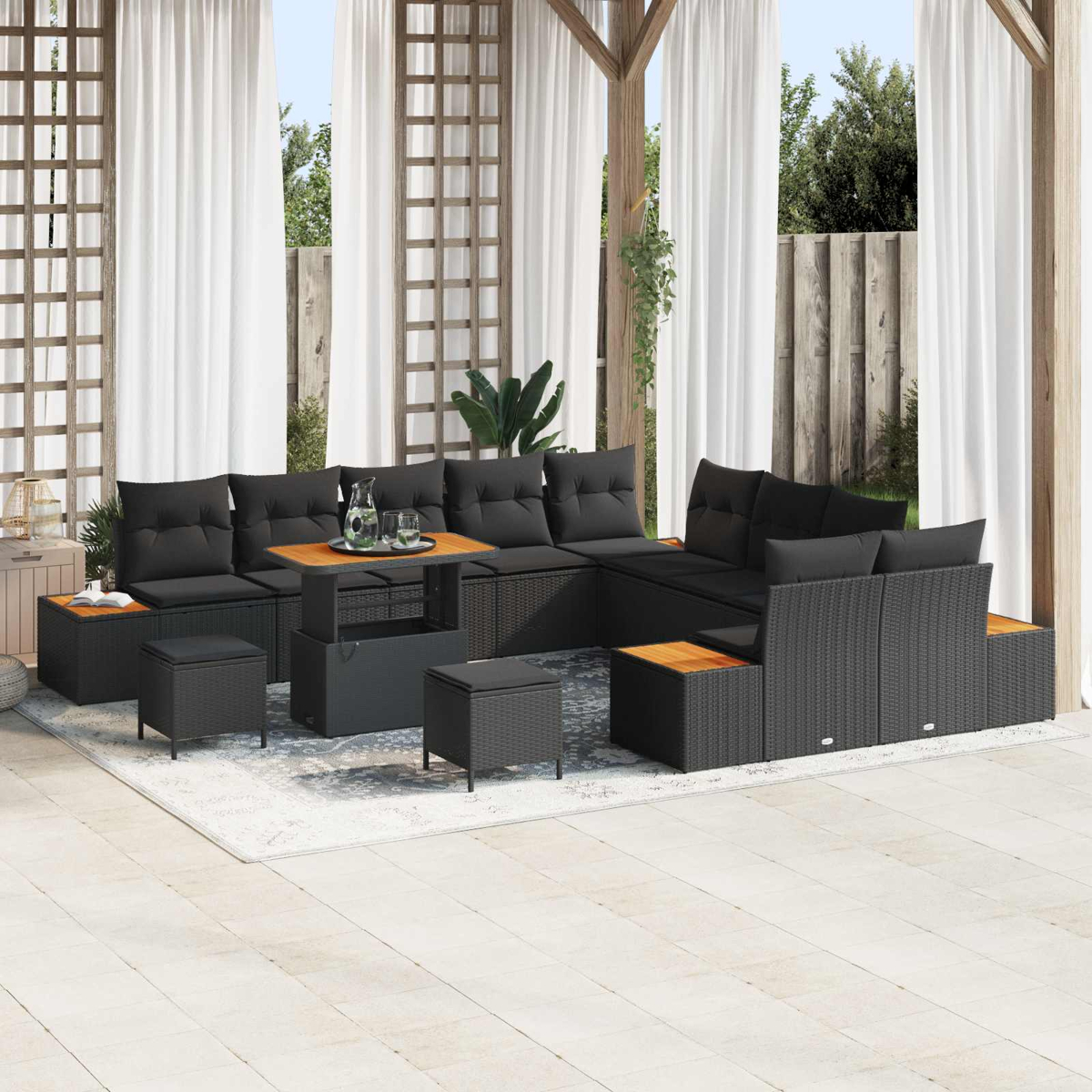 Un set lounge in rattan scuro con cuscini neri su un patio.