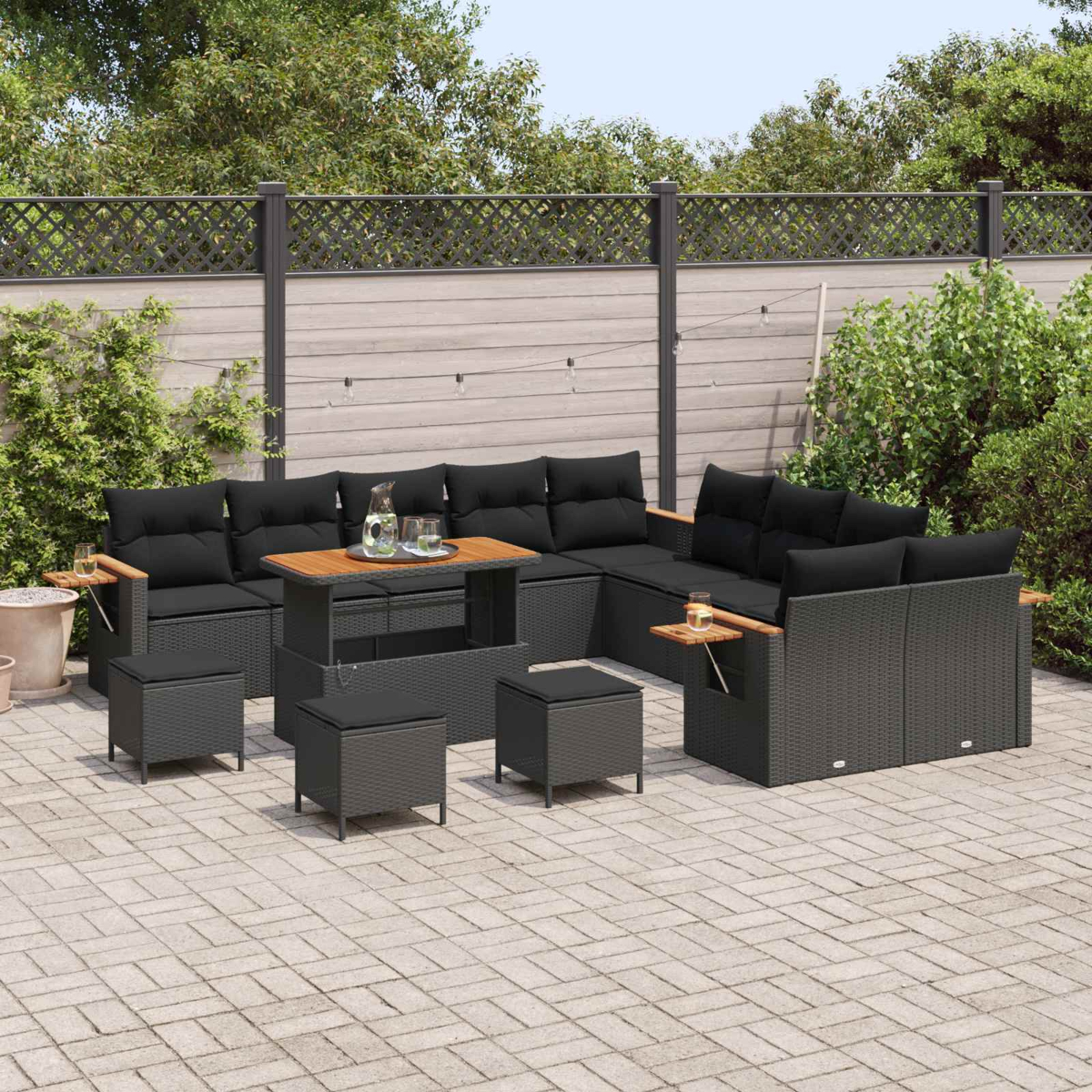 Set da lounge da esterno grigio scuro con cuscini neri su un patio pavimentato.