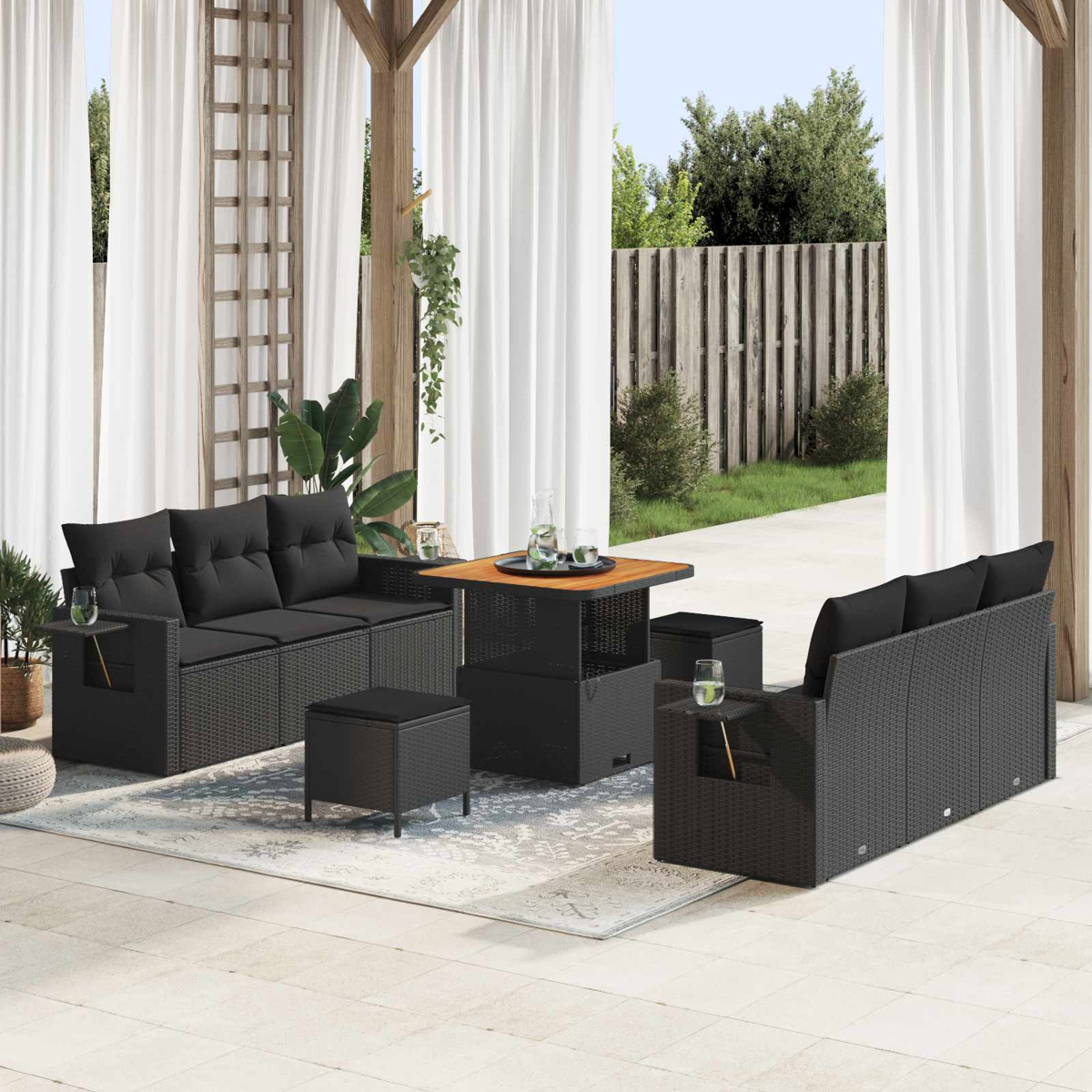 Dunkelgraue Rattansitzgruppe mit Tisch auf einer Terrasse.