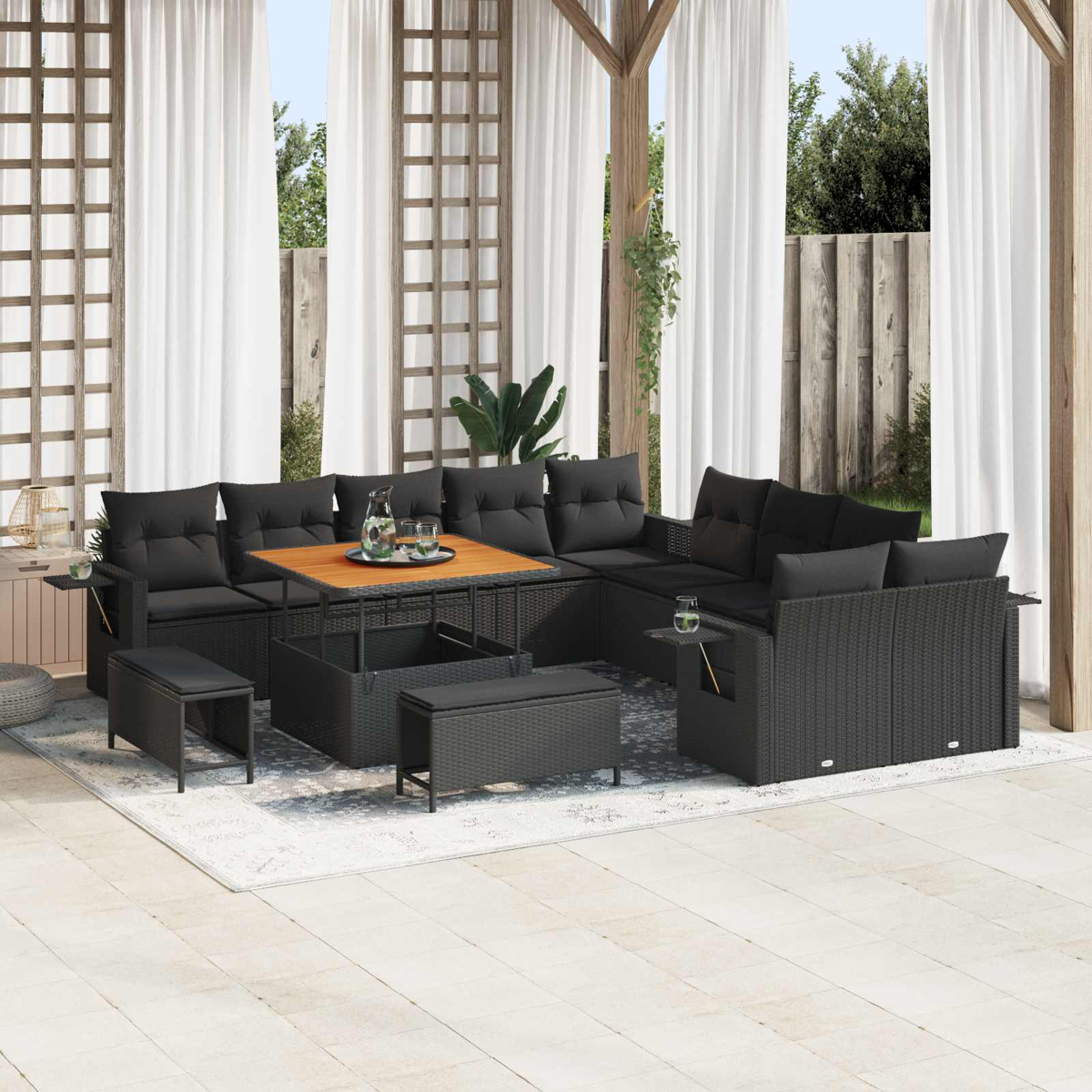 Schwarzes Rattan-Sitzmöbelset mit Tisch auf einer Terrasse unter einem Holzpavillon.