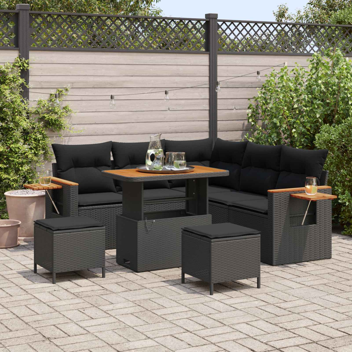 Ein moderner Rattan-Gartenmöbel-Set mit schwarzem Sofa, Tisch und Hockern.