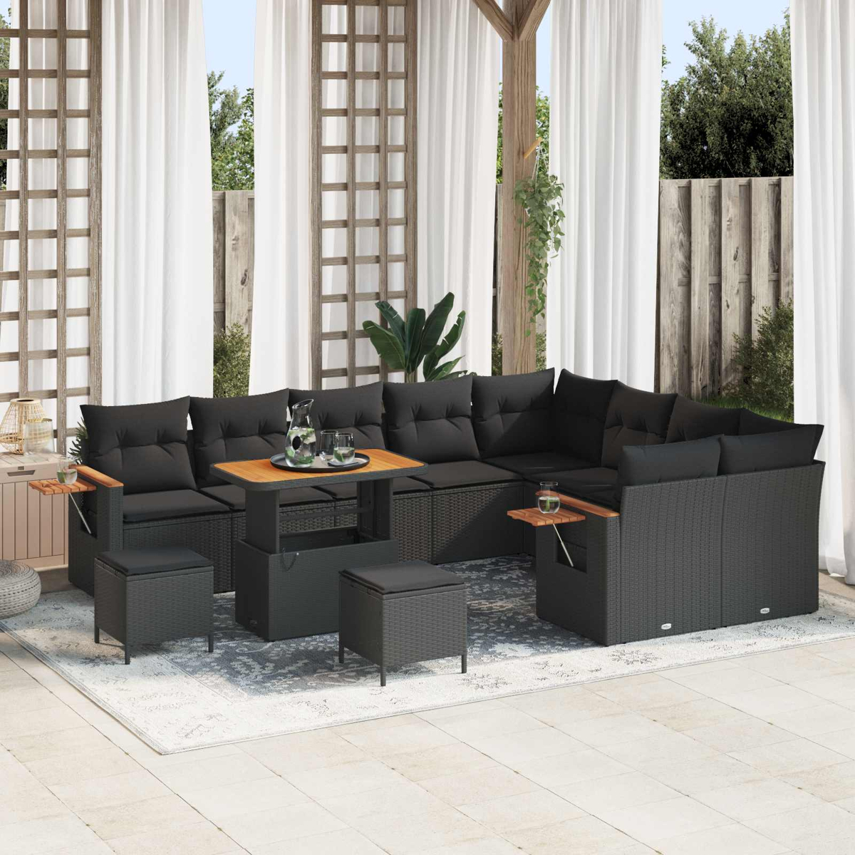 Dunkelgraue Polstermöbel mit Holztisch auf einer Terrasse mit weißen Vorhängen.