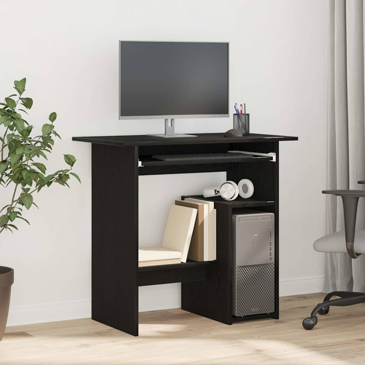 Schwarzer Computertisch mit Monitor, Tastatur, PC, Kopfhörern und Büchern.