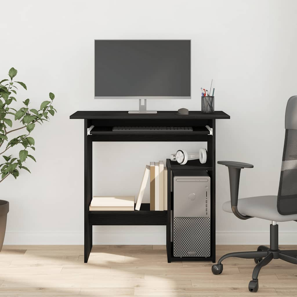 Ein schwarzer Computertisch mit einem Monitor, Tastatur, PC, Büchern und Kopfhörern.