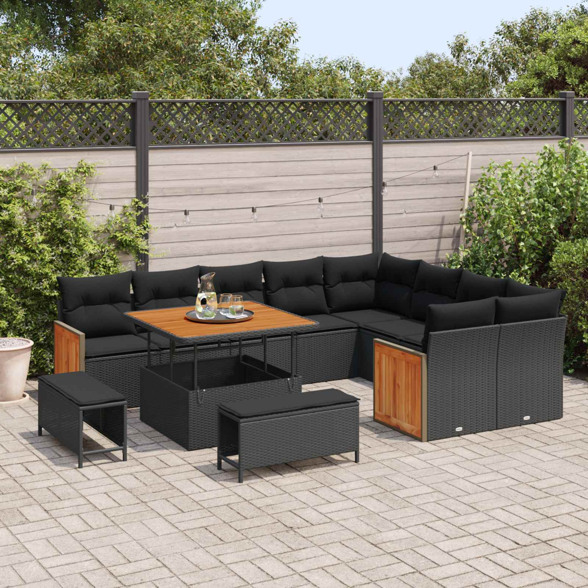 Gartenmöbel-Set mit schwarzem Rattan, Holztisch und zwei Hockern.