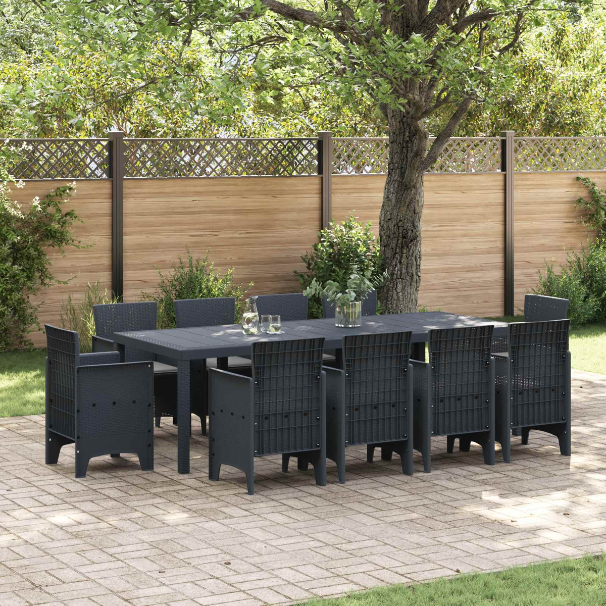 Dunkelgraues Gartenmöbel-Set mit Tisch und Stühlen auf einer Steinplatte.