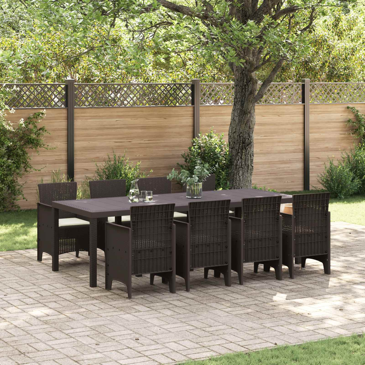 Dunkelbraunes Gartenmöbelset mit Tisch und acht Stühlen auf einer Kopfsteinpflasterterrasse.