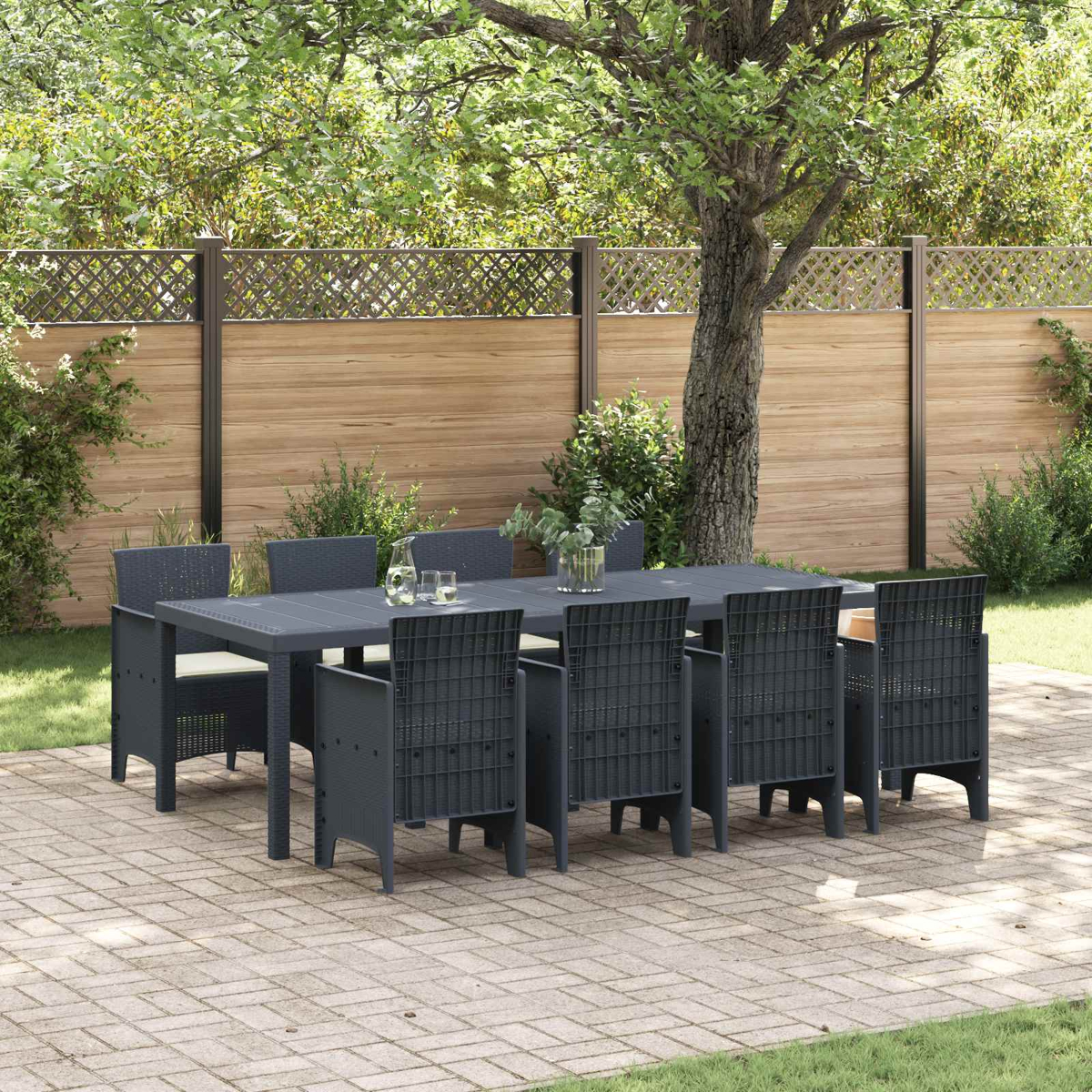 Ein dunkler Gartentisch mit acht Stühlen auf einer gepflasterten Terrasse.