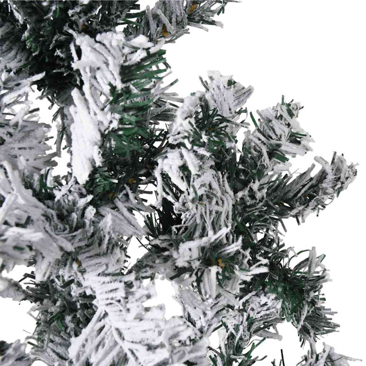 Detailaufnahme einer künstlichen Tanne mit weißen Schneeflocken auf grünen Nadeln.