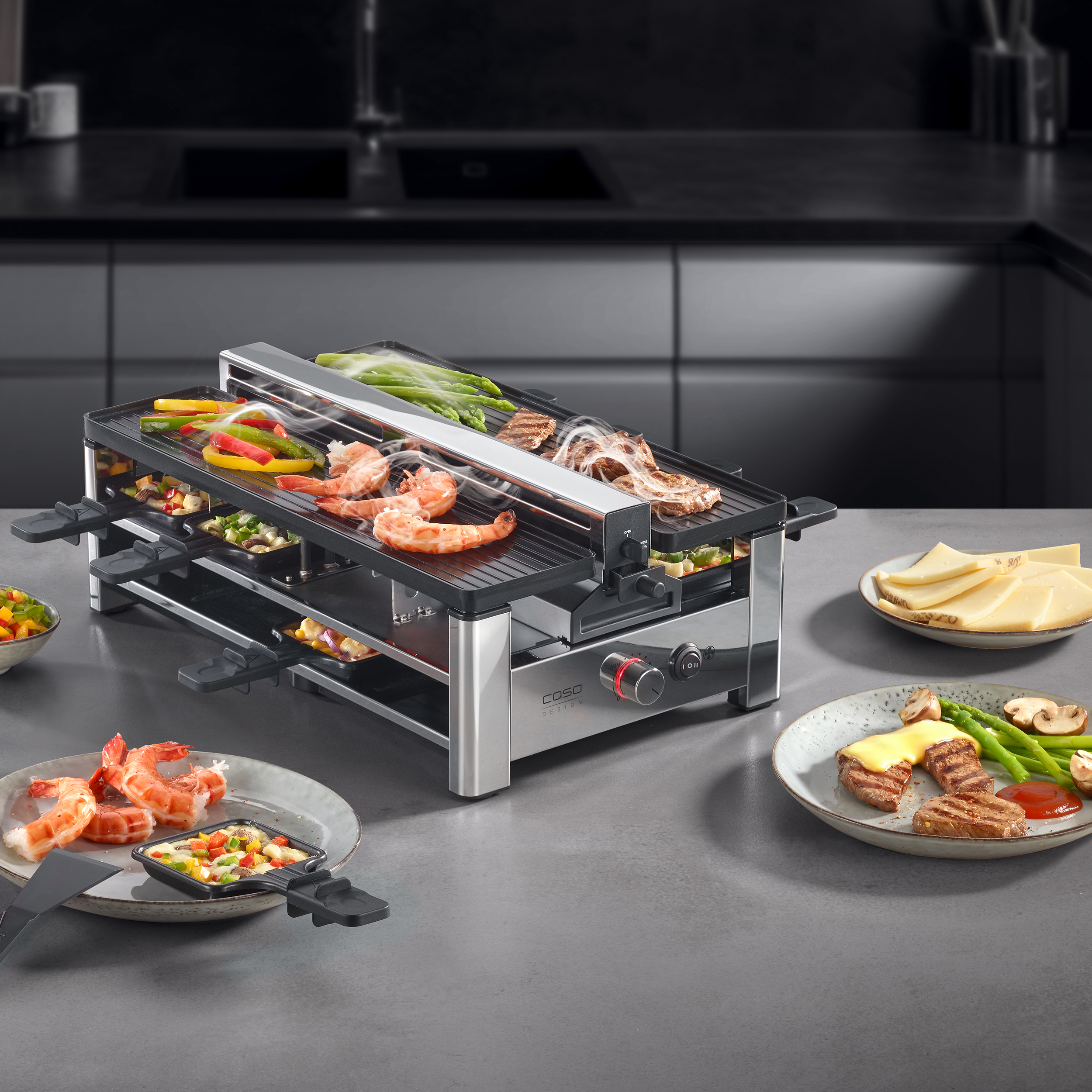 Ein Raclette-Grill mit Garnelen, Steak, Gemüse und Käse auf einem Tisch.