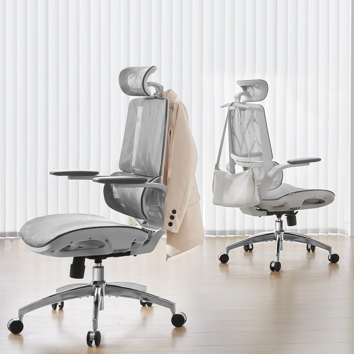 Zwei moderne Bürostühle mit Netzrücken, einer mit Blazer, der andere mit Tasche.
