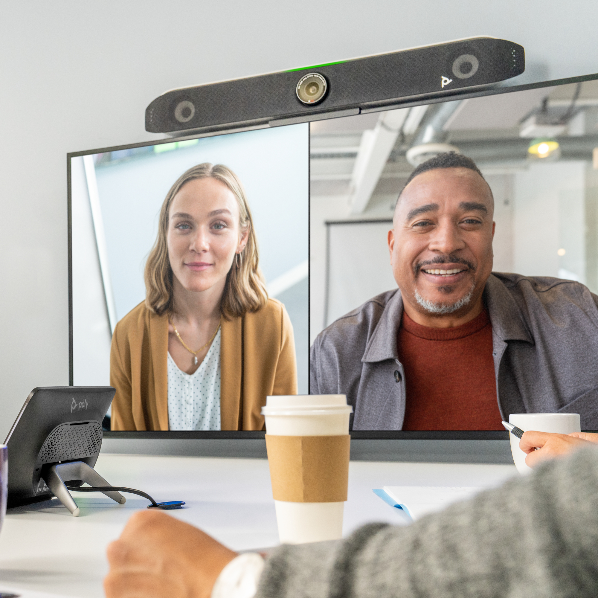 Due persone in videoconferenza, una donna e un uomo, sorridono alla telecamera.