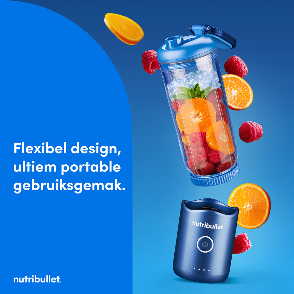 Un mixeur Nutribullet bleu avec des fruits et de la glace dans la tasse flottant.