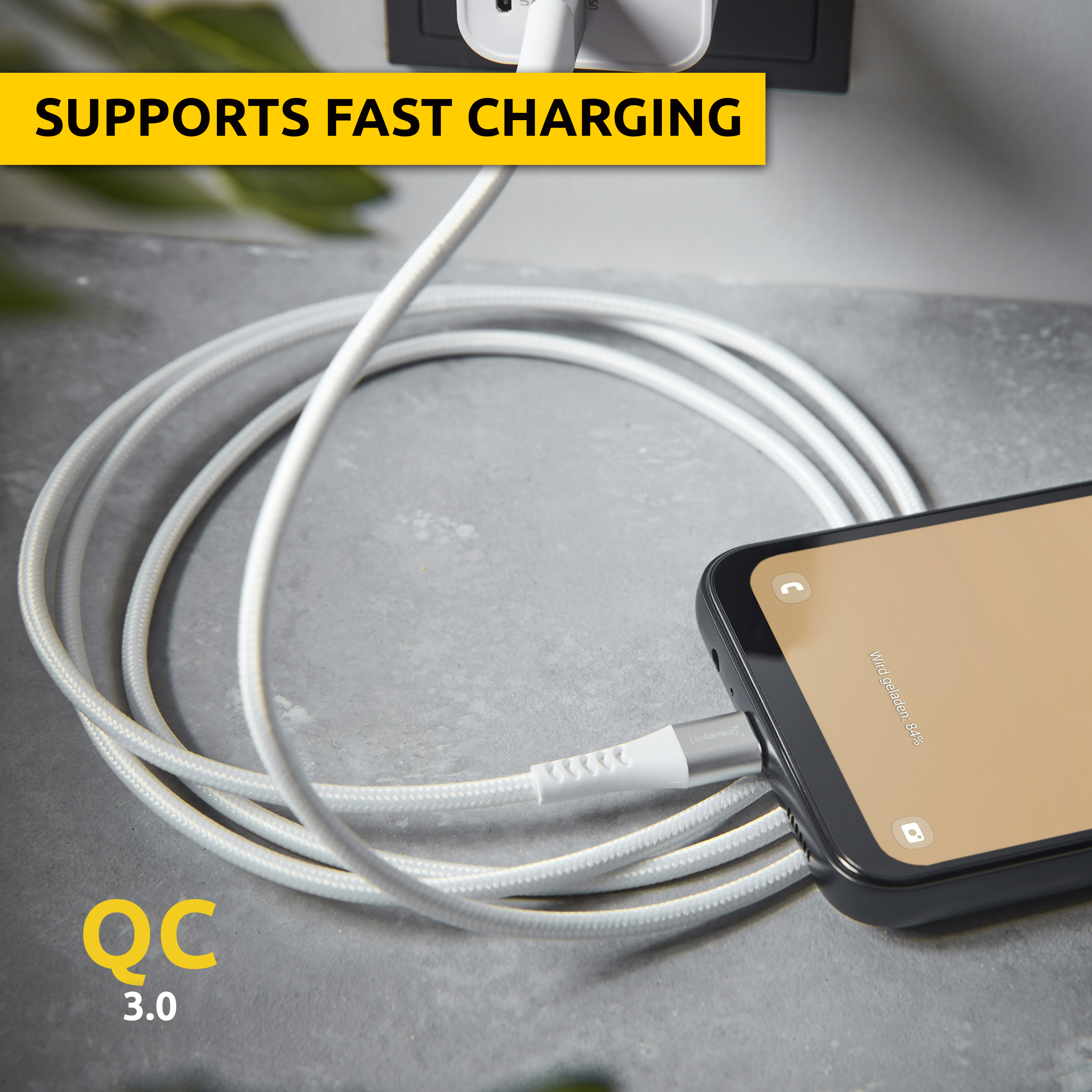 Un câble de chargement blanc connecte un smartphone à un adaptateur secteur. QC 3.0.