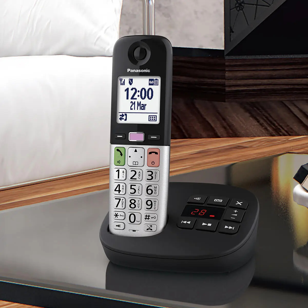 Ein schnurloses Panasonic-Telefon mit großem Display und Tasten auf einer Ladestation.
