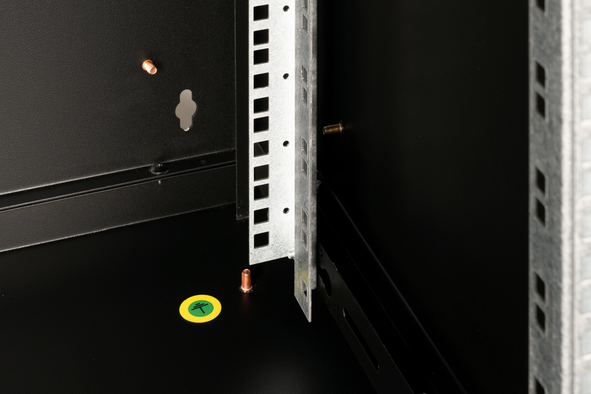 Nahaufnahme eines schwarzen Serverschranks mit silbernen Rackschienen und Schrauben.