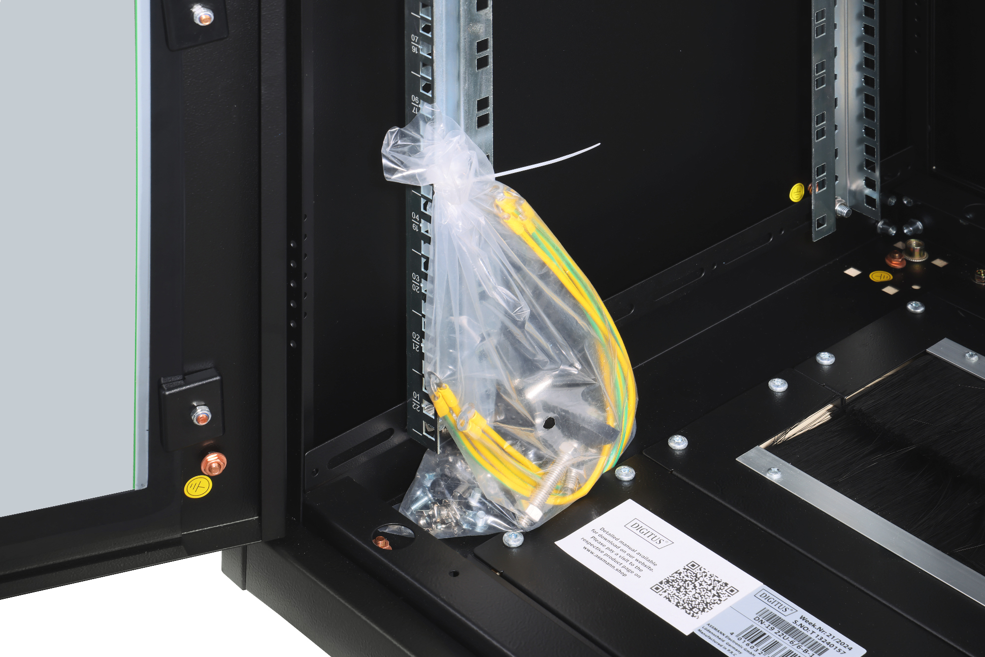 Ein Rack mit gelben und grünen Kabeln in einer Plastiktüte und Schrauben.