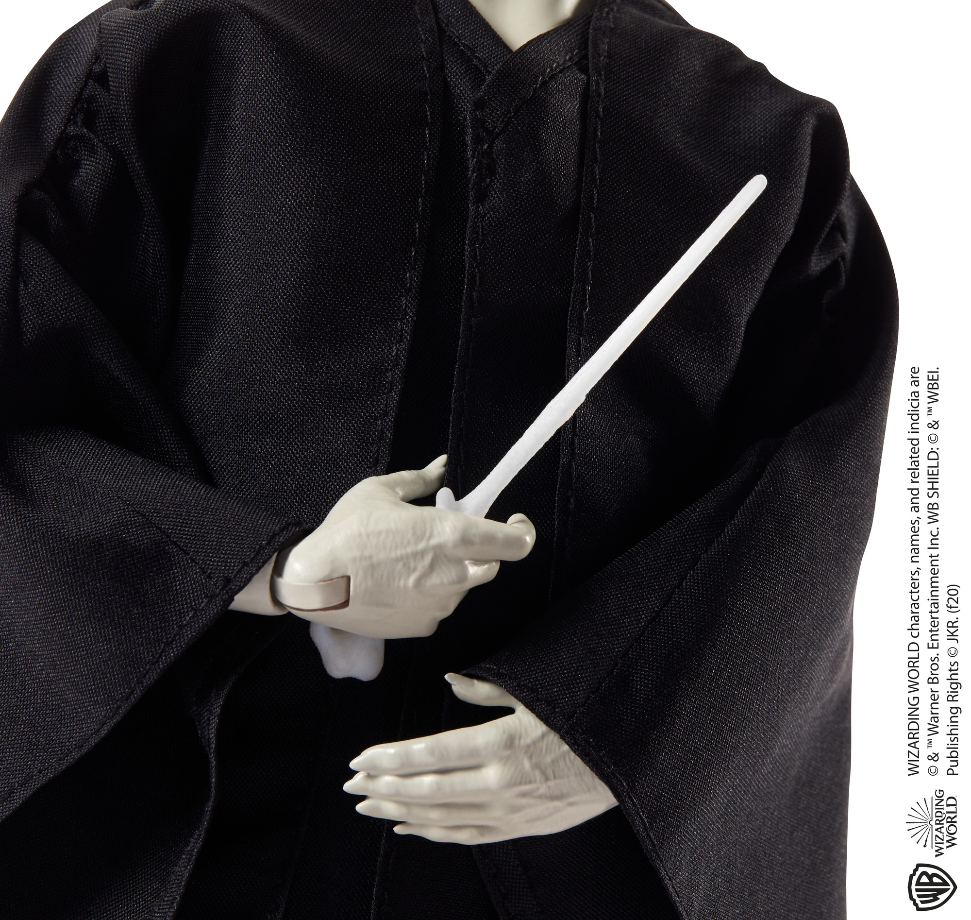 Una figura in veste nera tiene una bacchetta bianca.