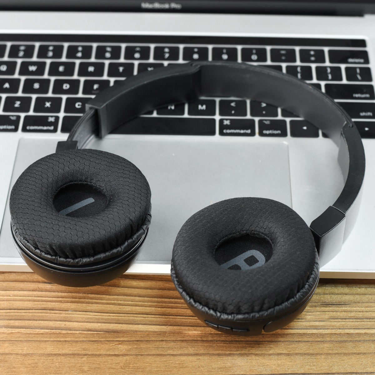 Auriculares negros sobre un teclado de portátil. Vista de cerca.