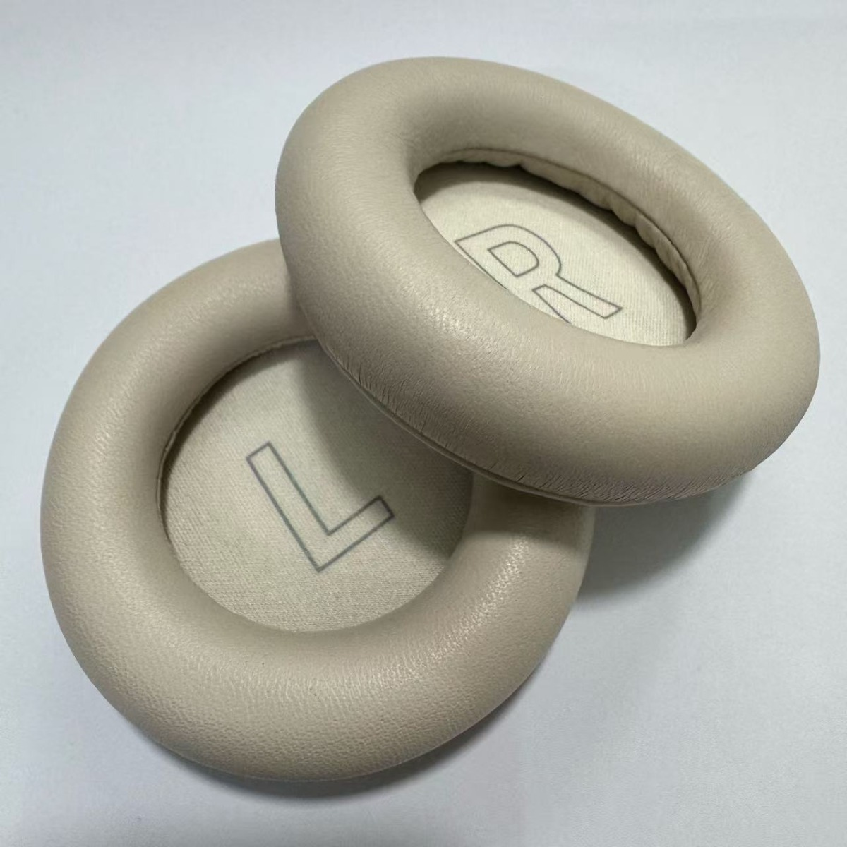 Dos almohadillas beige con marcas L y R sobre fondo blanco.