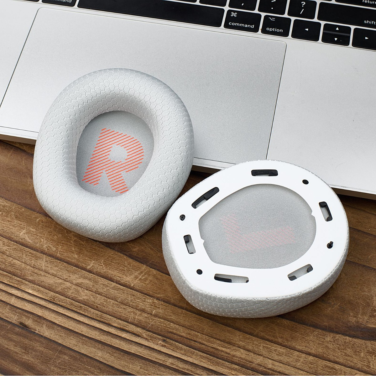 Dos almohadillas blancas para auriculares con logo R rojo sobre portátil y mesa.