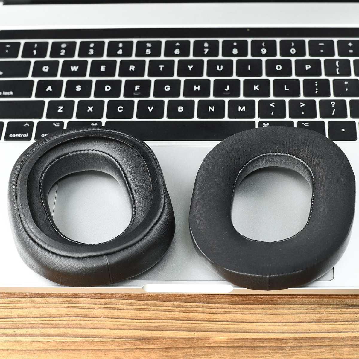 Dos almohadillas negras descansan sobre el teclado de un portátil.
