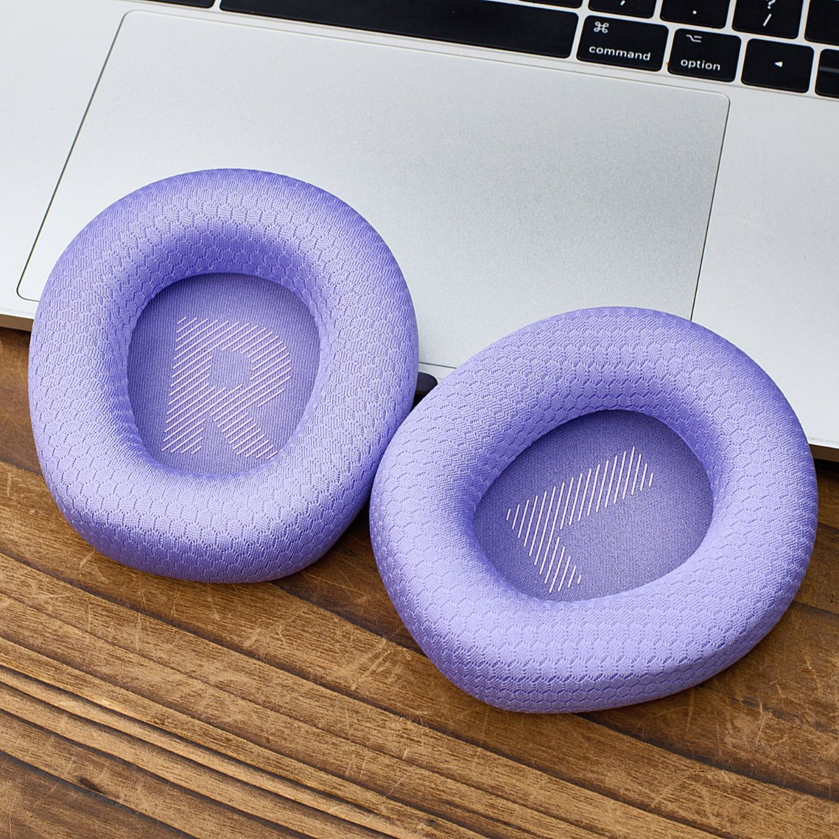 Dos almohadillas lavanda con símbolos R y L, sobre un portátil y mesa de madera.