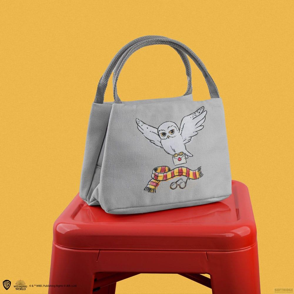 Graue Tasche mit Eule, Brief, Schal und Brille auf rotem Hocker.