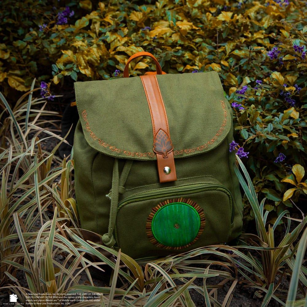Grüner Rucksack mit braunen Lederdetails und Hobbit-Türen-Applikation.