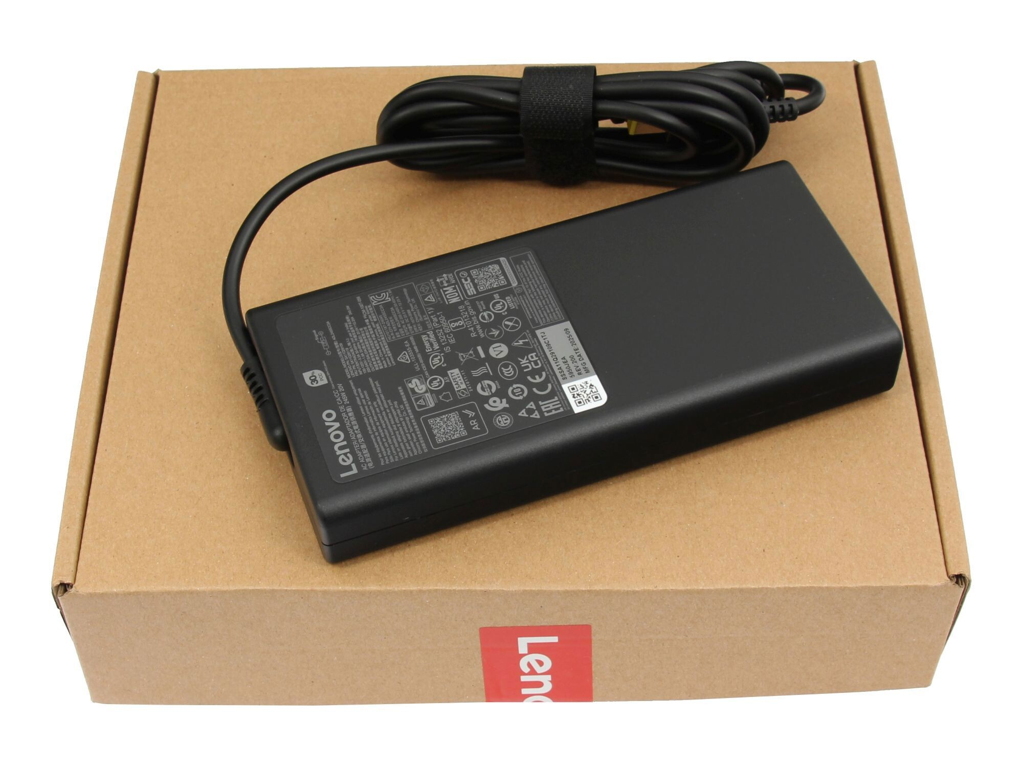 Schwarzes Lenovo Netzteil mit Kabel liegt auf einem braunen Karton.