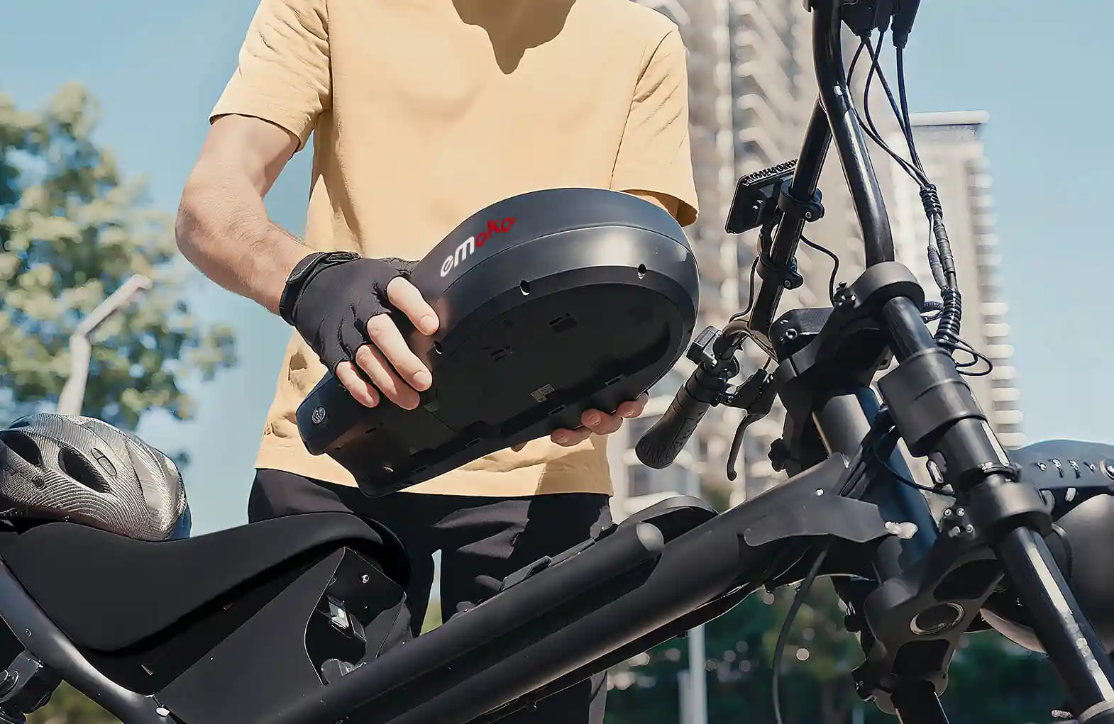 Uomo tiene parte nera e-bike, manubrio bici in primo piano.