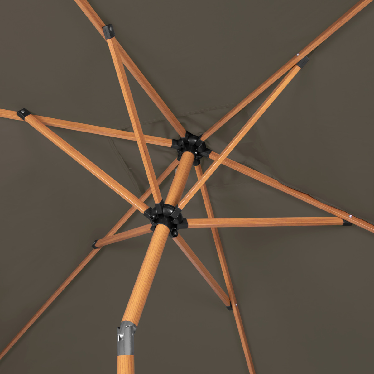 Underside of an umbrella with wooden ribs and brown fabric.