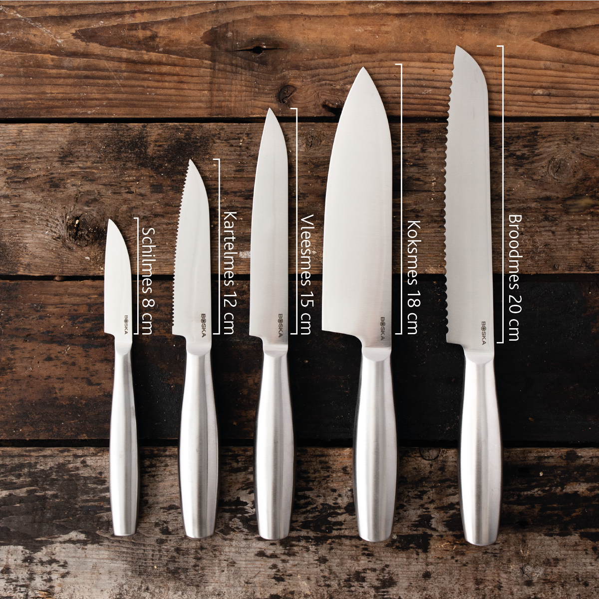 Five silver knives with handles on a wooden background.