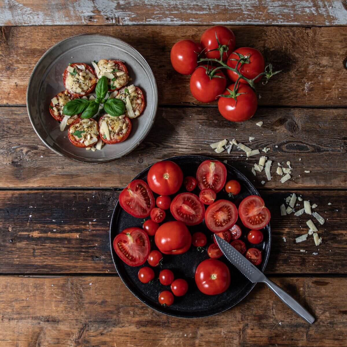 Whole and sliced tomatoes, baked tomato slices with cheese and basil.