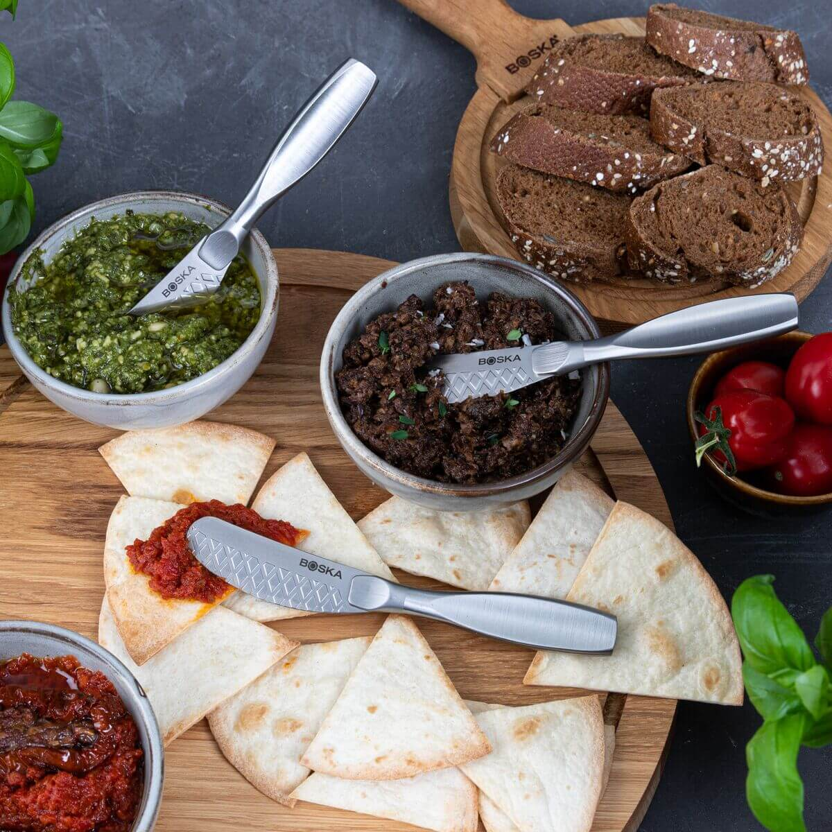 Cheese knives on tortilla chips with pesto, olive paste and bread.
