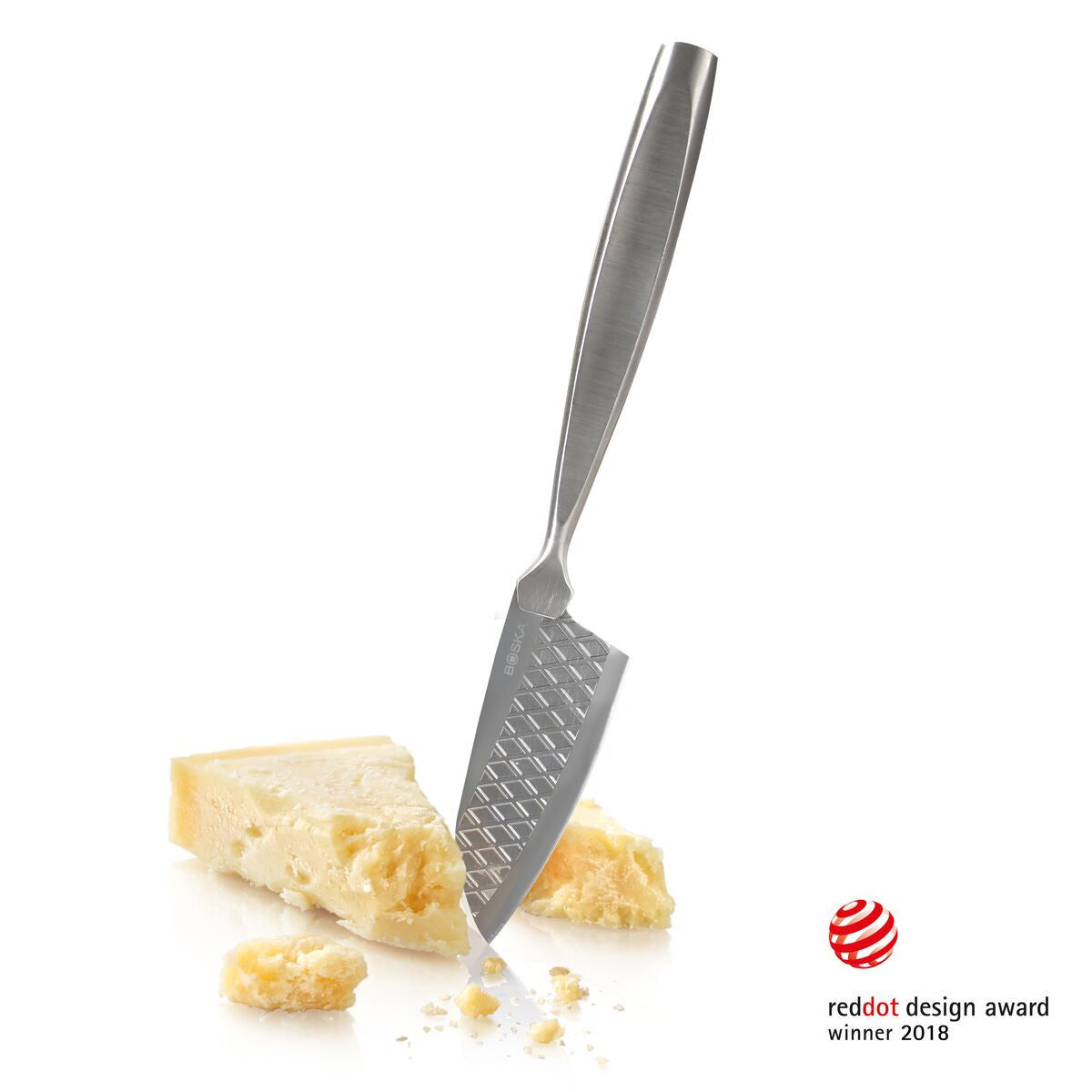 A knife is stuck in a piece of cheese with other cheese pieces nearby.
