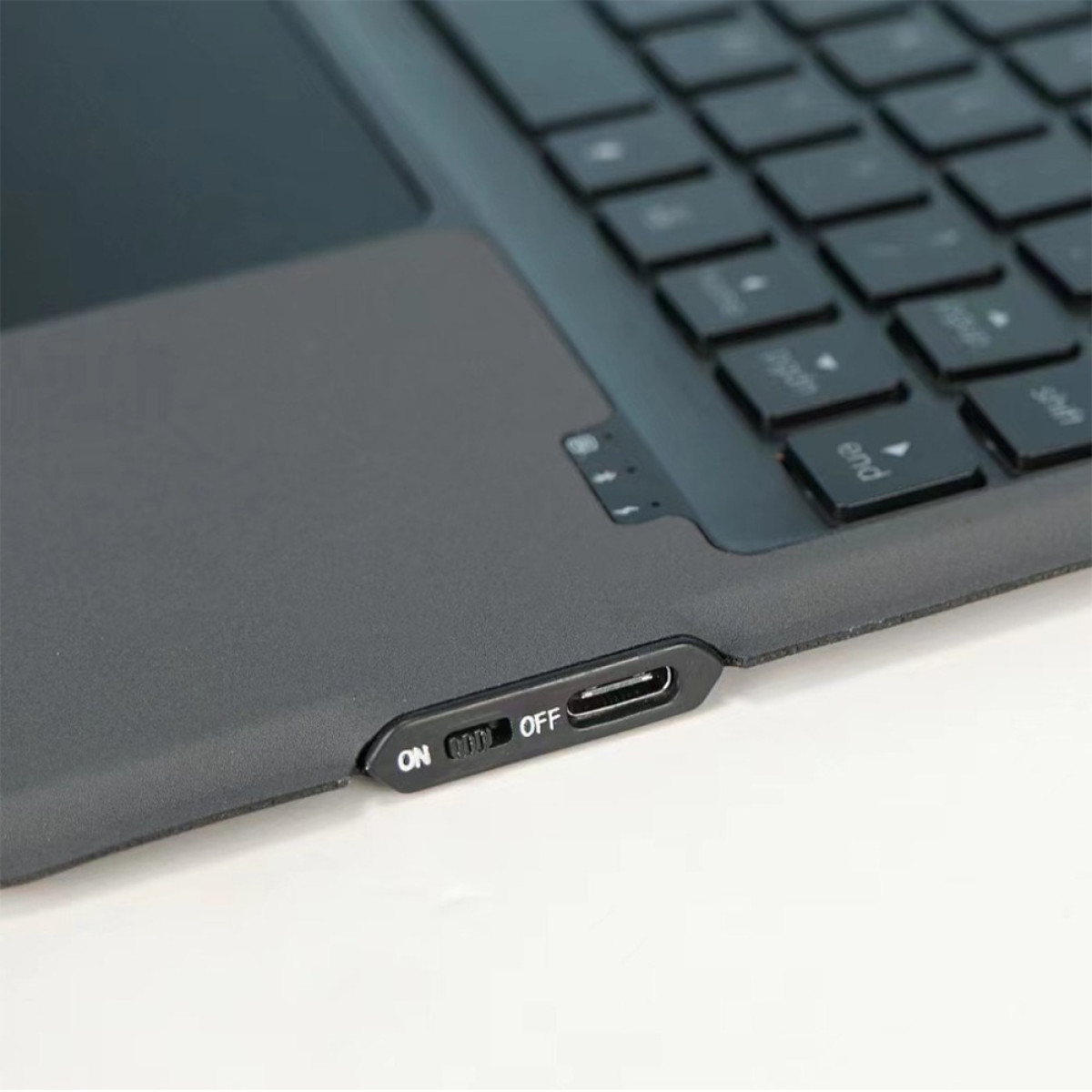 Zbliżenie czarnej klawiatury z przełącznikiem ON/OFF i portem USB-C.